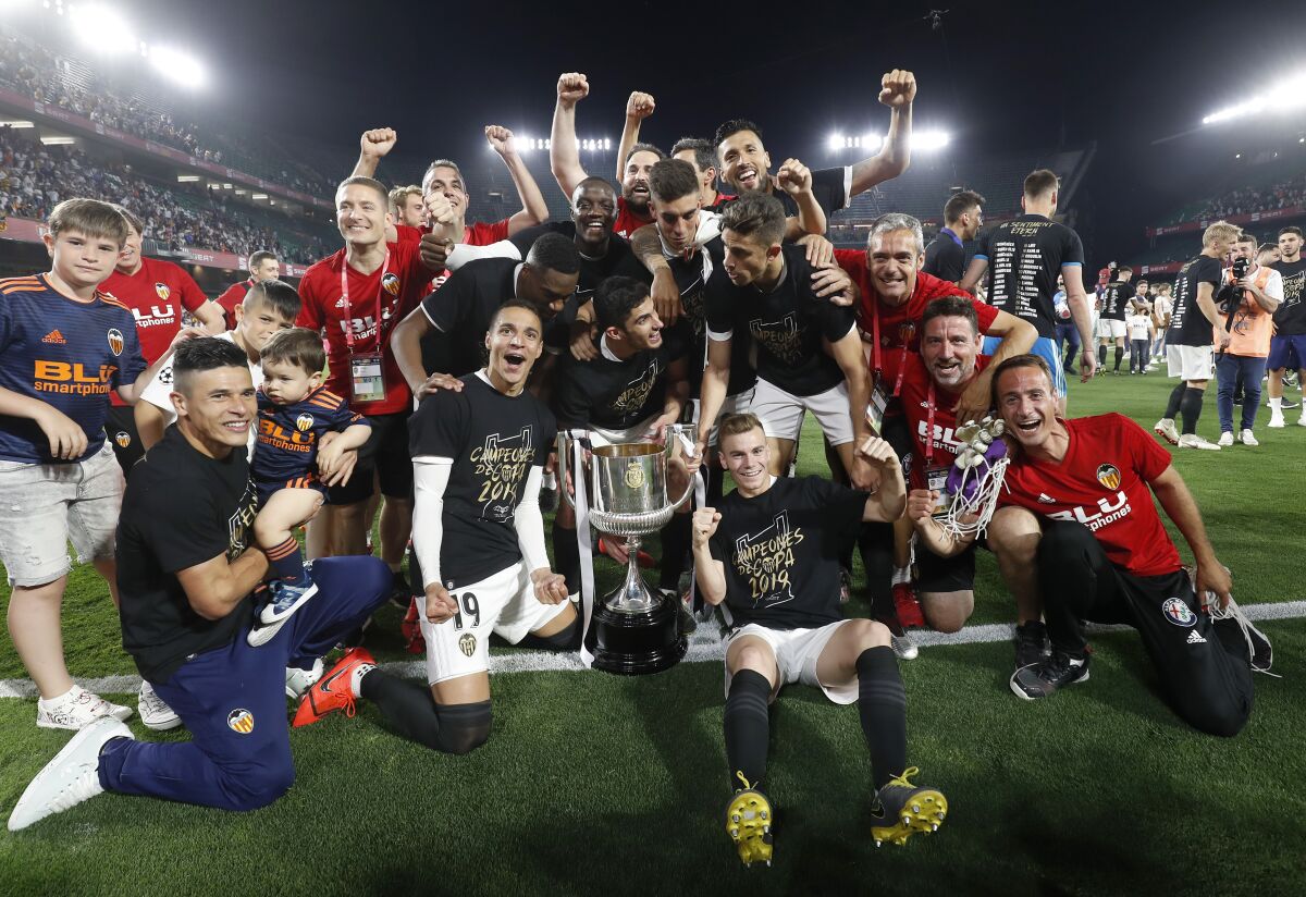 FILE - Valencia players celebrate with the trophy after winning the Copa del Rey soccer match final between Valencia CF and FC Barcelona at the Benito Villamarin stadium in Seville, Spain, on May 25, 2019. Valencia hosts Cádiz in a single-elimination game in the quarterfinals of the Copa del Rey. Valencia is looking to return to the semifinals after a two-year absence. It won its eighth Copa title in the 2018-19 season (AP Photo/Miguel Morenatti, File)