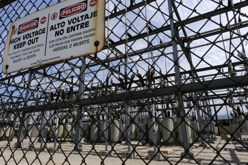 High voltage signs are posted on the Department of Water and Power sub station E in the North Hollywood section of Los Angeles on Saturday, Aug. 15, 2020. California has ordered rolling power outages for the first time since 2001 as a statewide heat wave strained its electrical system. (AP Photo/Richard Vogel)
