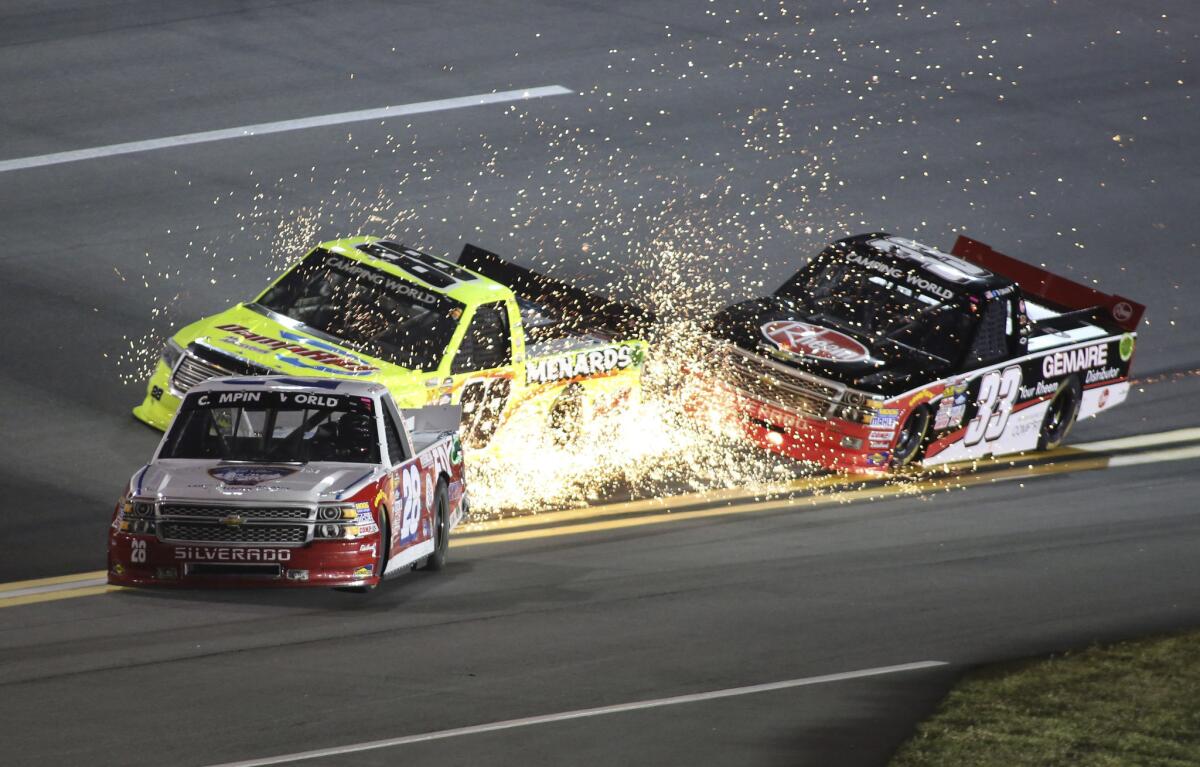 Sparks fly as the trucks of NASCAR drivers Ryan Ellis (28), Matt Crafton (88) and Ty Dillon (33) collide during the race at Daytona International Speedway on Friday night.
