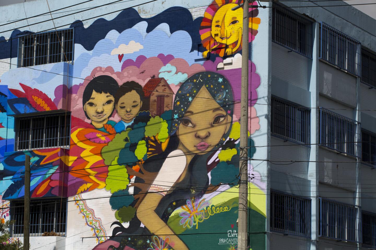 Una mujer que huye de su casa con sus hijos ocupa un mural callejero diseñado y pintado por solicitantes de asilo junto con la artista mexicana Eva Bracamontes en Ciudad de México.