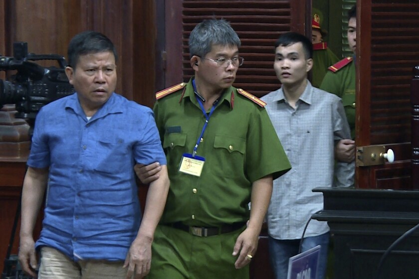 Chau Van Kham, left, is escorted into a courtroom in Ho Chi Minh City, Vietnam, on Monday.