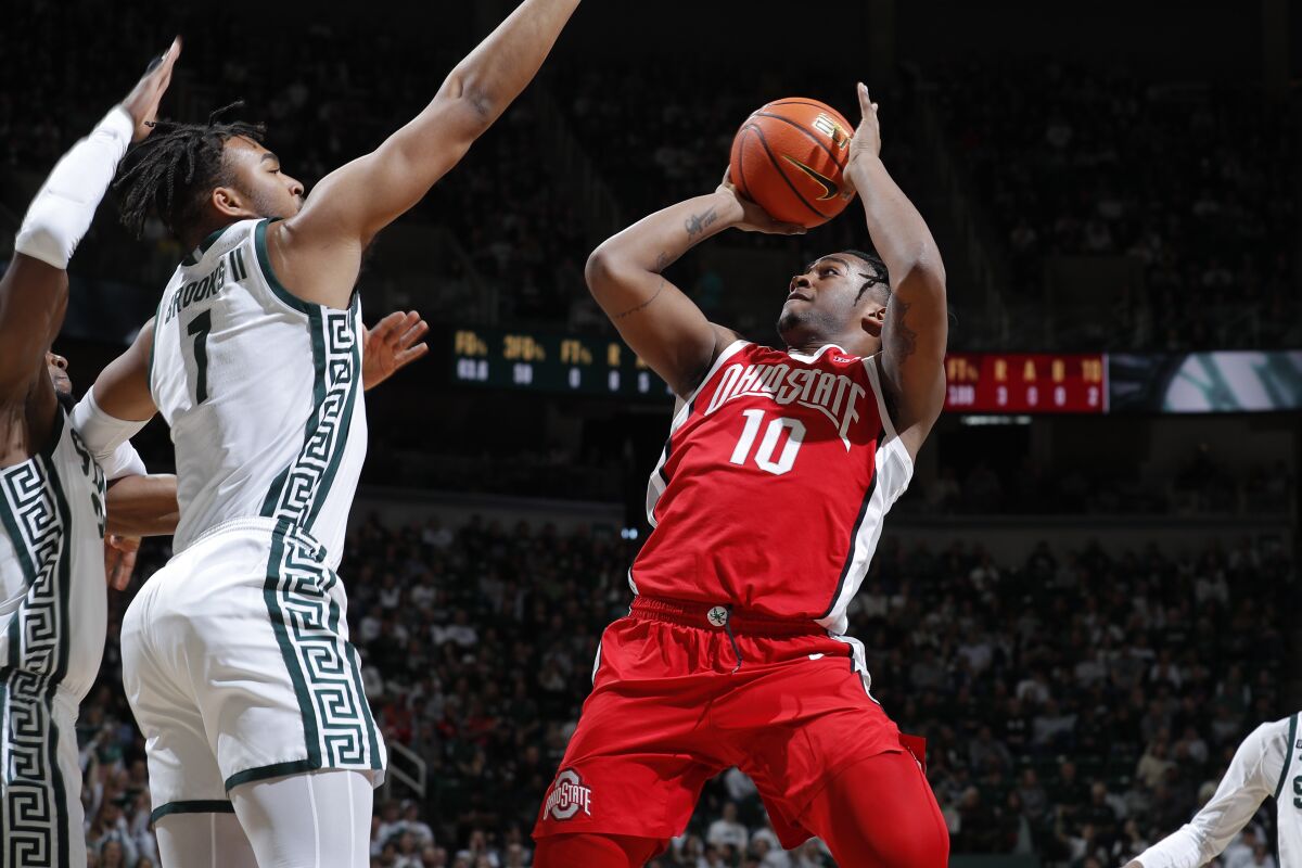 Ohio State's Brice Sensabaugh, right, shoots over Michigan State's Pierre Brooks during the first half of an NCAA college basketball game, Saturday, March 4, 2023, in East Lansing, Mich. (AP Photo/Al Goldis)