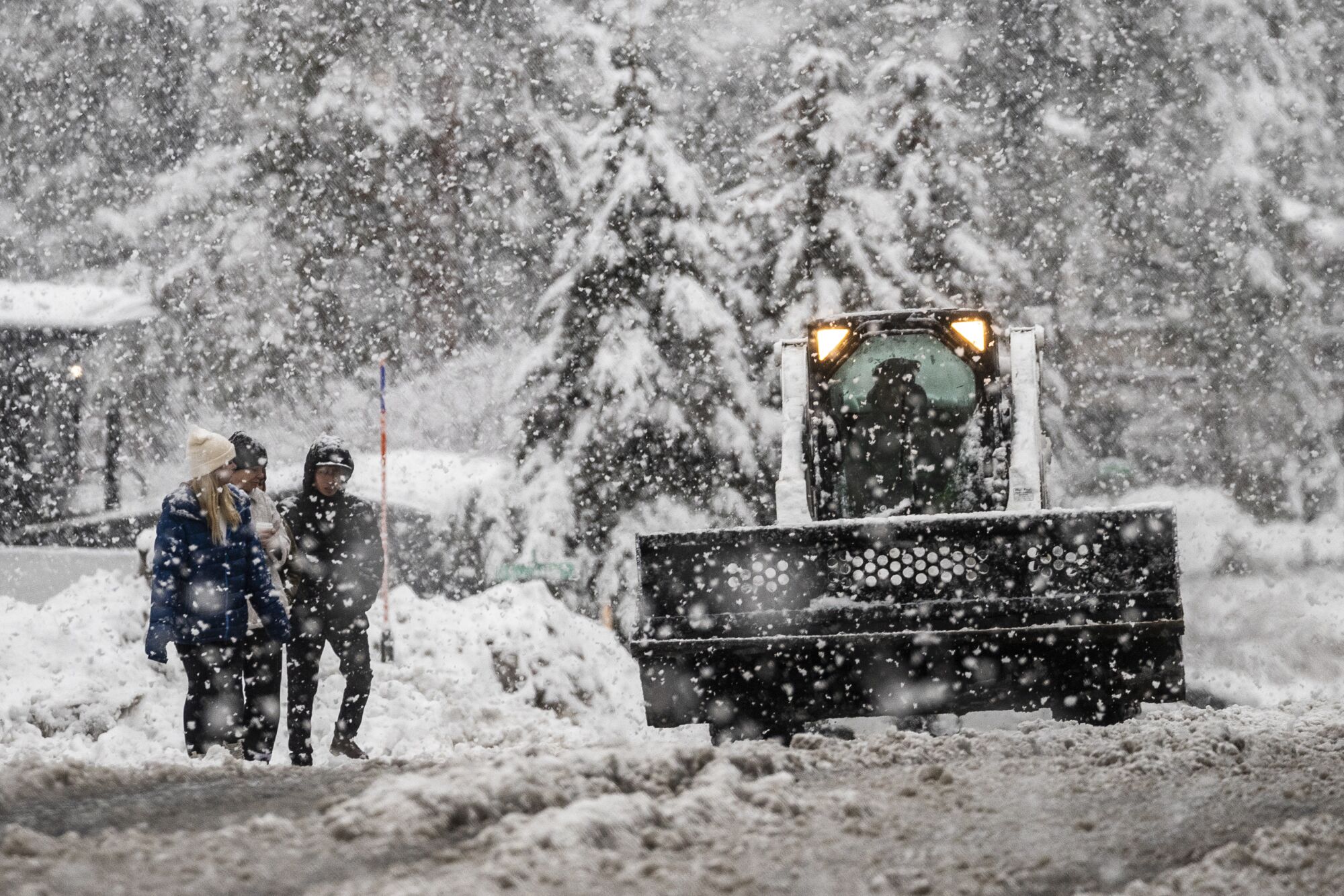 A snow plow passes pedestrians   in South Lake Tahoe  