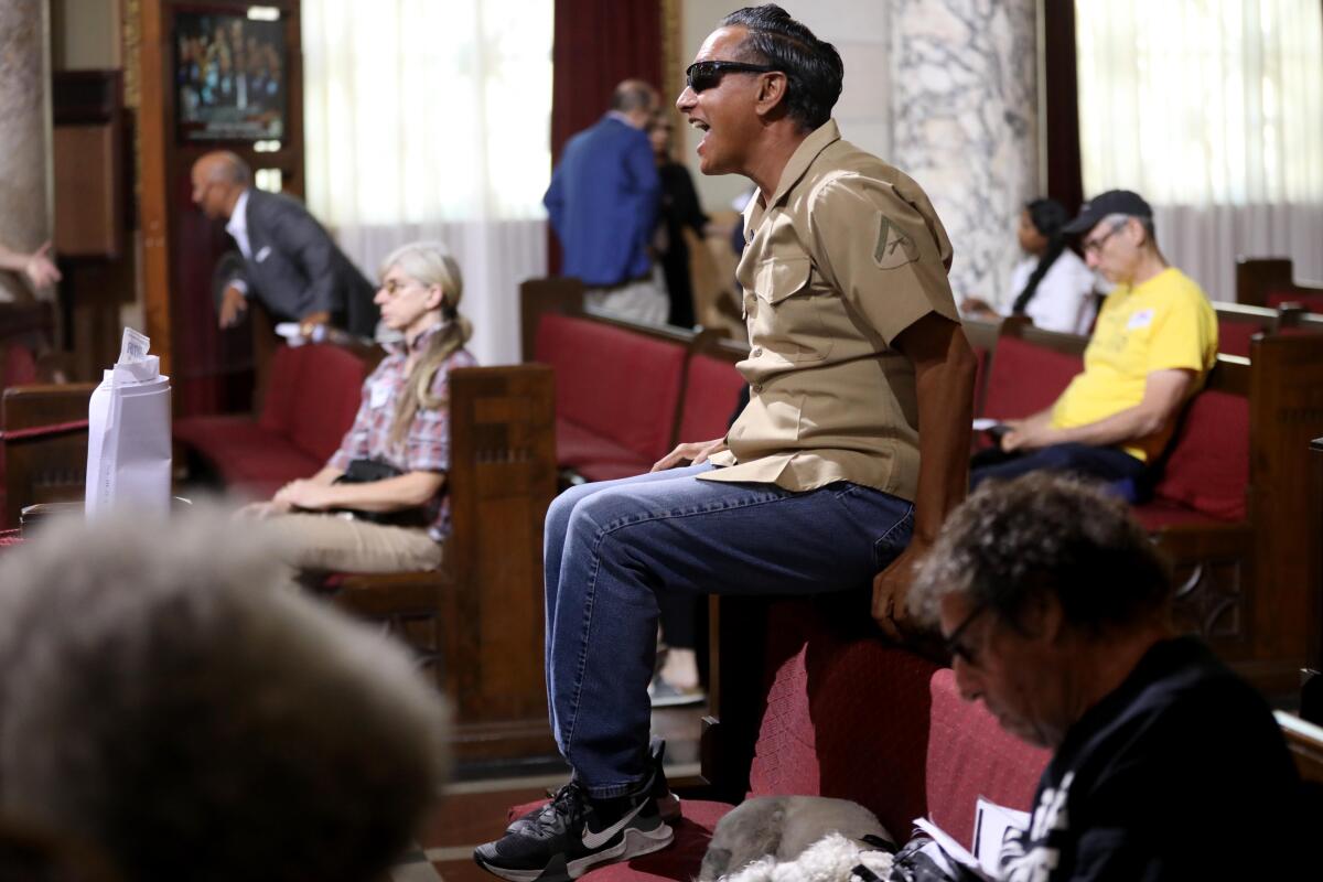 A man sitting in the audience shouts during an L.A. City Council meeting