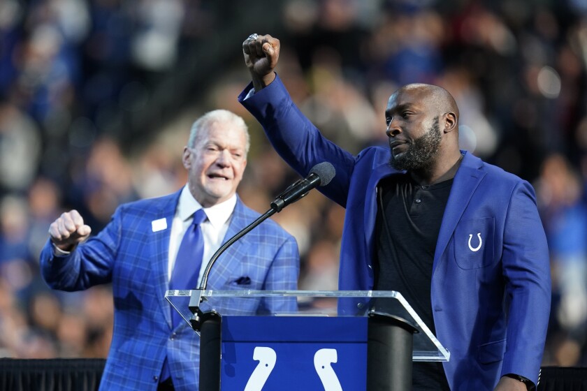 Former Indianapolis Colts' Robert Mathis, right, reacts after being inducted into the Ring of Honor by Colts owner Jim Irsay during a ceremony at halftime in an NFL football game against the Tampa Bay Buccaneers, Sunday, Nov. 28, 2021, in Indianapolis. (AP Photo/Michael Conroy)