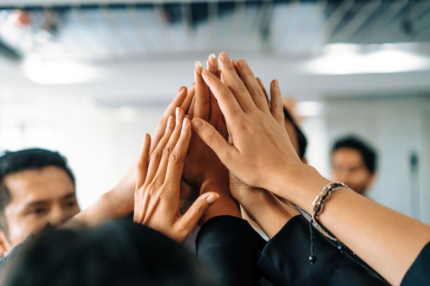 Business people raise hands together with joy and success