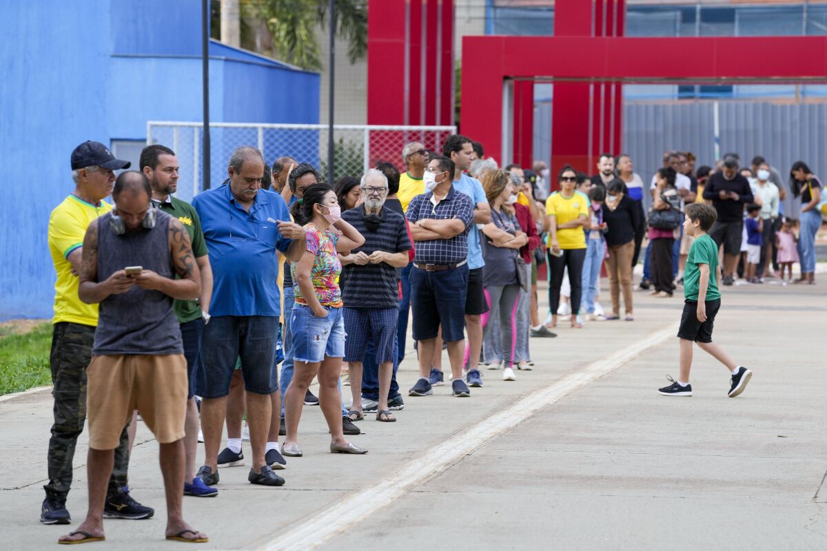 Voters line up outside at a polling station.