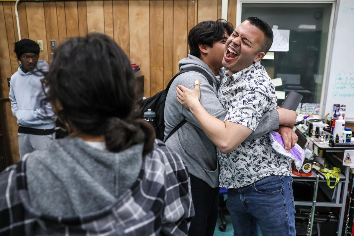 Student Angel Zanabria offers a congratulatory birthday hug to Inglewood High School band director Joseph Jauregui.