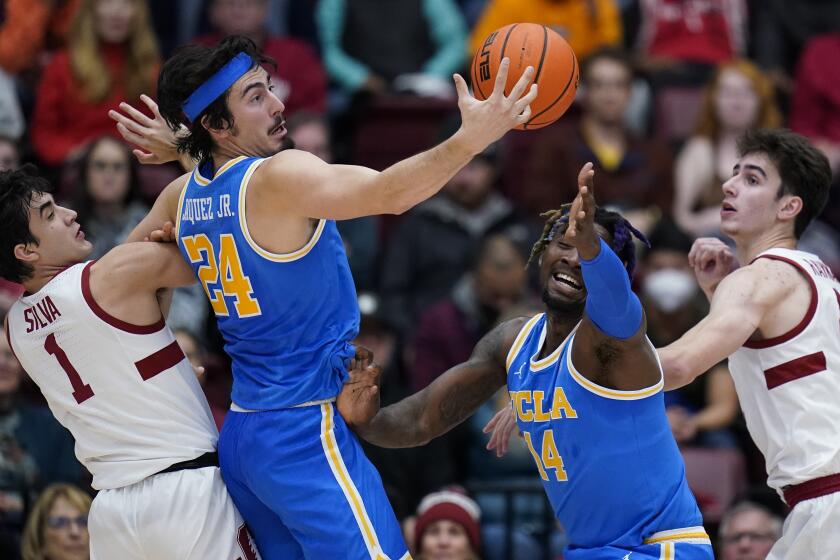 Stanford guard Isa Silva (1) and UCLA guard Jaime Jaquez Jr. (24) compete for possession of the ball during the first half of an NCAA college basketball game in Stanford, Calif., Thursday, Dec. 1, 2022. (AP Photo/Godofredo A. Vásquez)