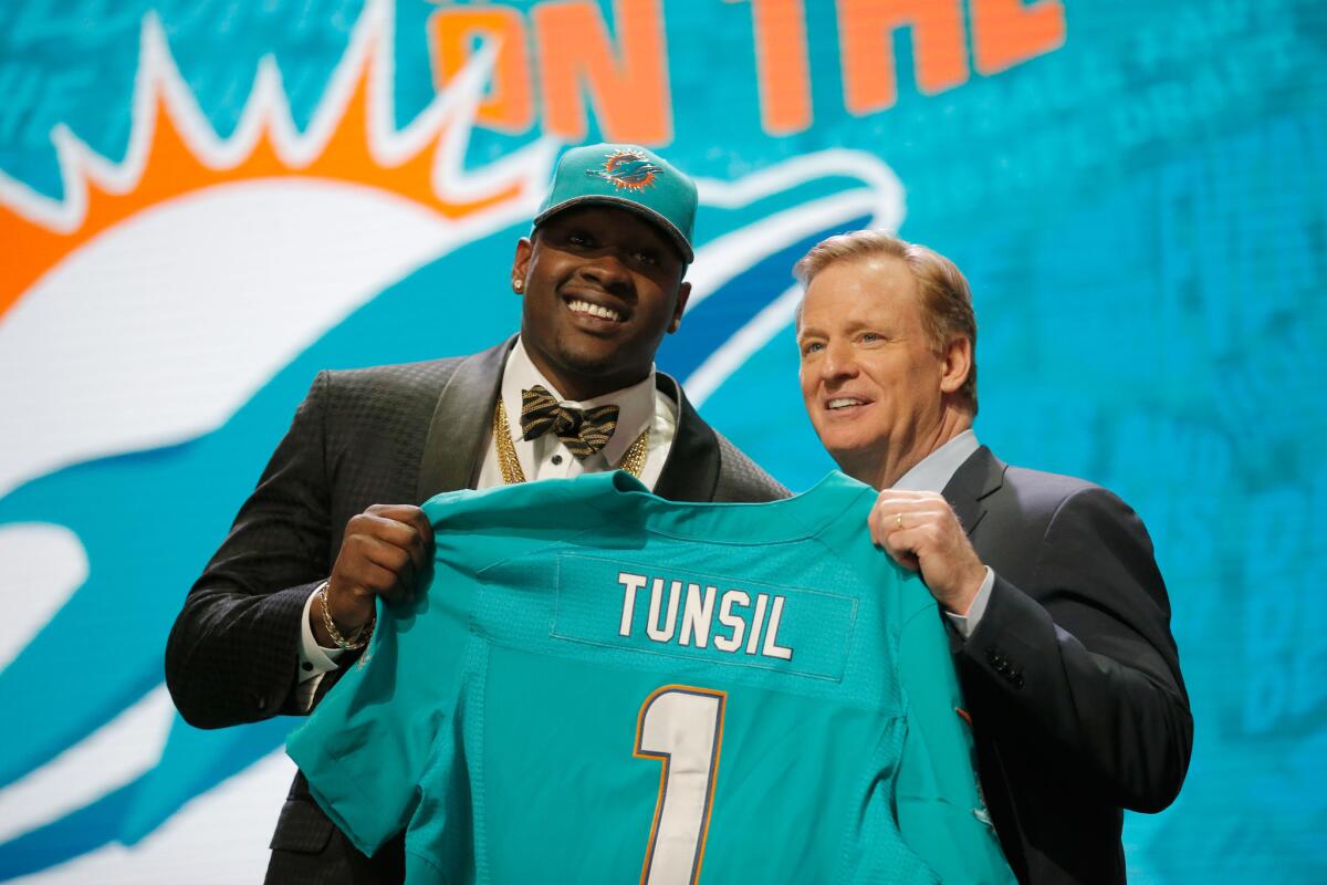Ole Miss OT Laremy Tunsil holds up a jersey with NFL Commissioner Roger Goodell after being drafted No. 13 overall by the Miami Dolphins.