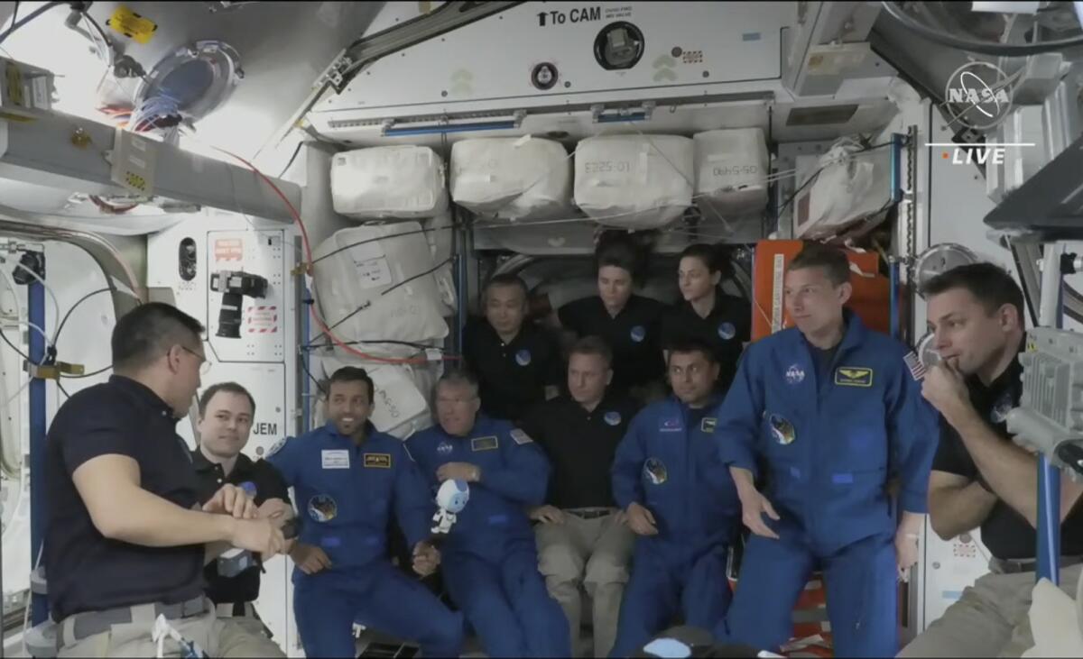 A crew of nearly a dozen gathers in the International Space Station. 