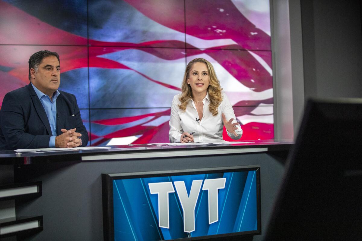 Cenk Uygur, The Young Turks host and CEO, left, and Ana Kasparian, host and executive producer, record the show at the Los Angeles studio.