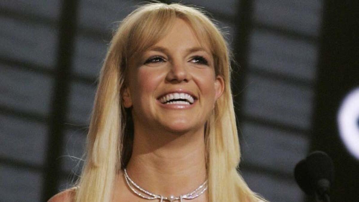 Britney Spears smiles and wears a sparkly necklace. 