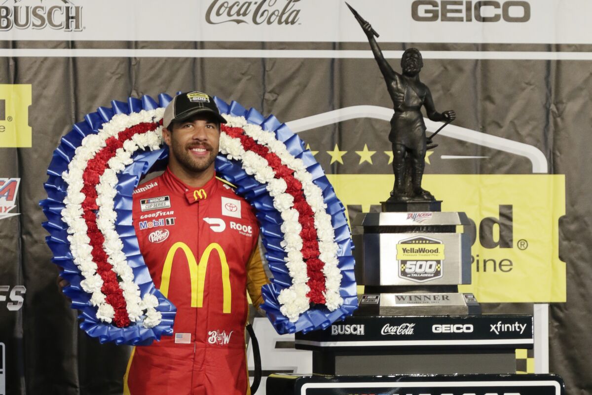 Bubba Wallace stands with the trophy after winning a NASCAR Cup series auto race Monday, Oct. 4, 2021, in Talladega, Ala. (AP Photo/Russell Norris)