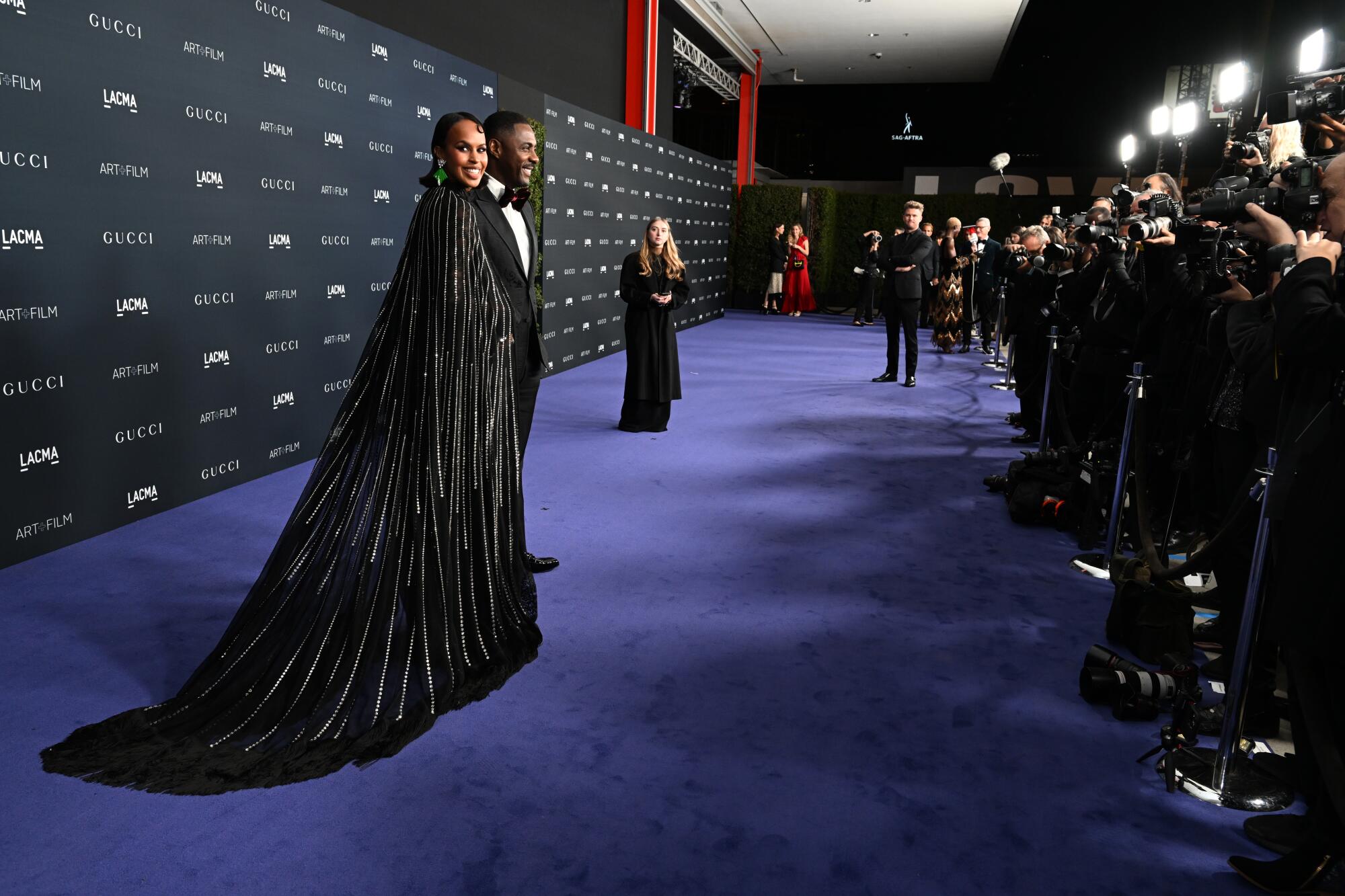 Sabrina Dhowre Elba and Idris Elba wear black formalwear. 