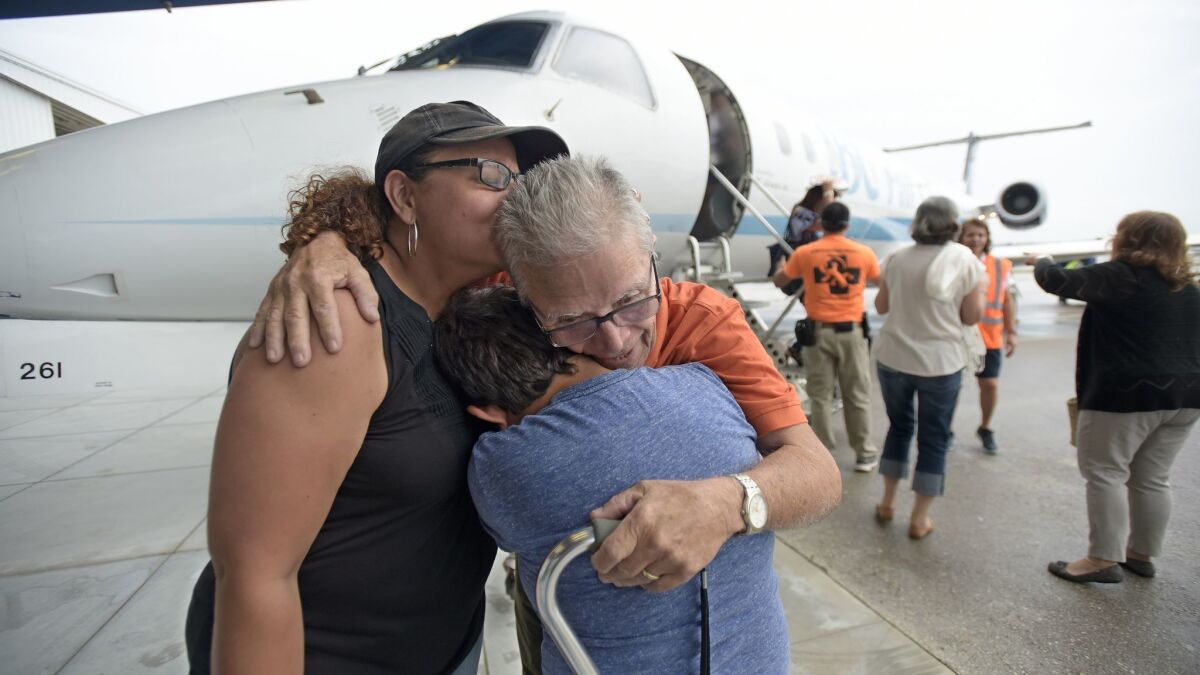 Angel Delgado hugs family members relatives after arriving in Fort Lauderdale on Friday on a flight that evacuated seniors from Puerto Rico.