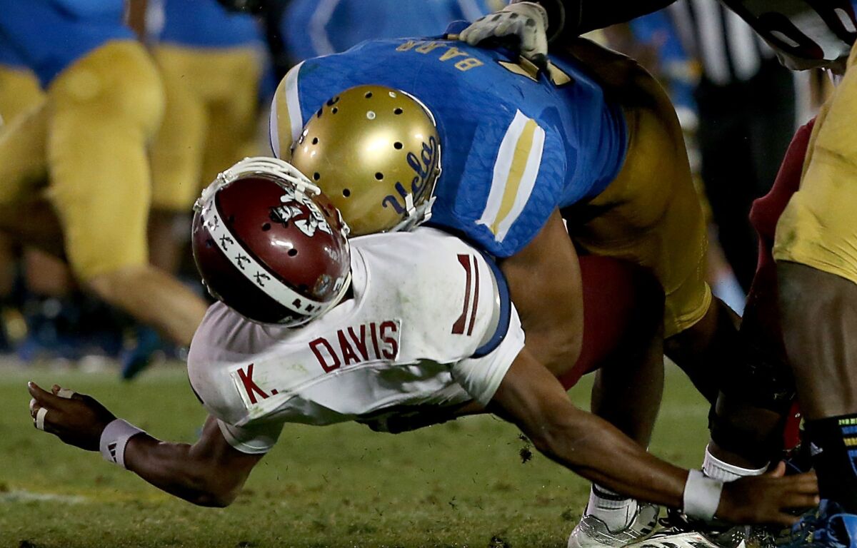 UCLA linebacker Anthony Barr puts a big hit on New Mexico State quarterback King Davis III in the third quarter Saturday at the Rose Bowl.