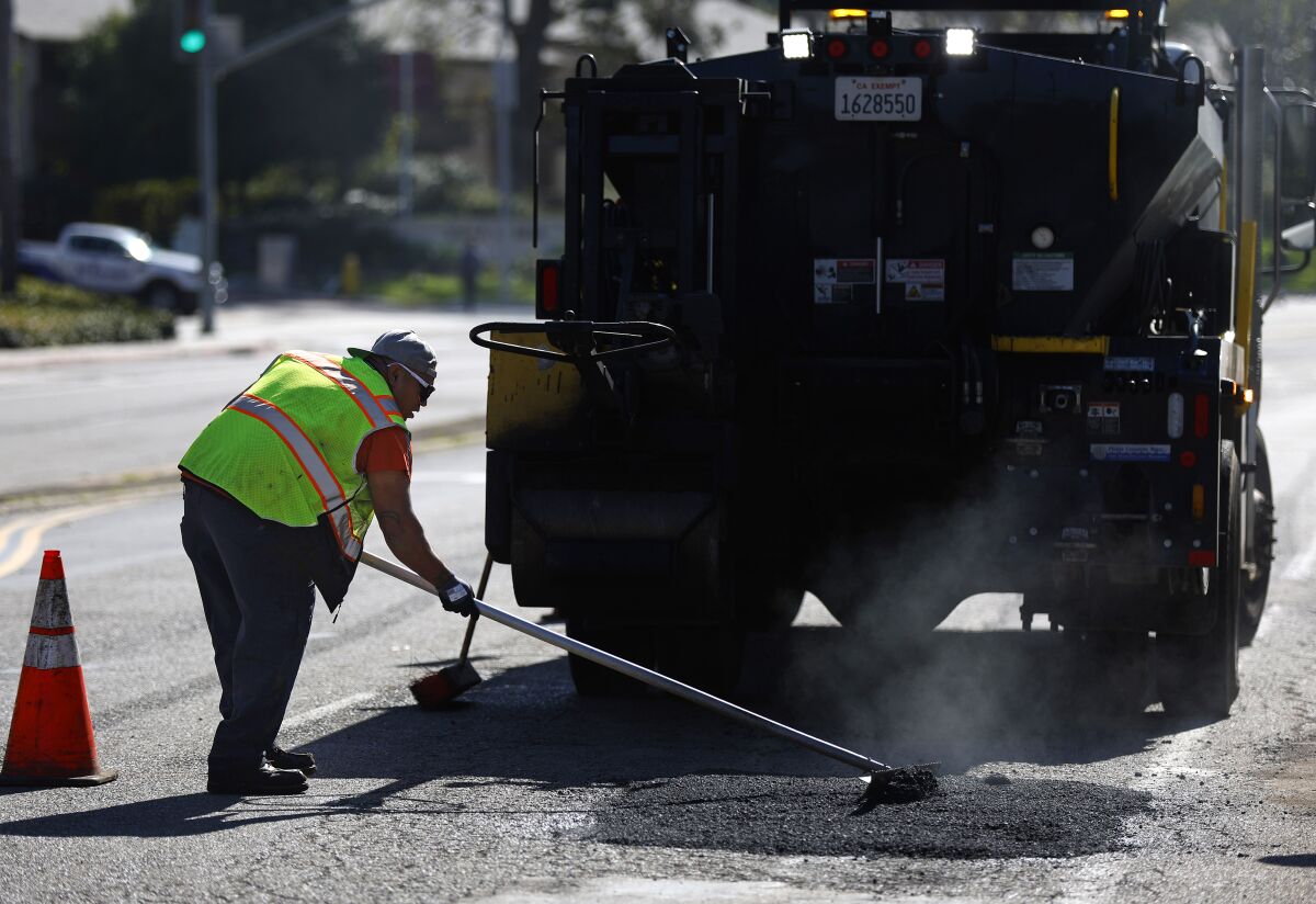 A San Diego city worker repairs a pothole in January.
