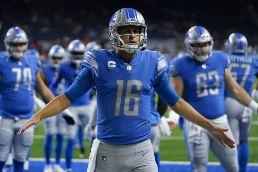 Detroit Lions quarterback Jared Goff (16) welcomes teammates onto the field.
