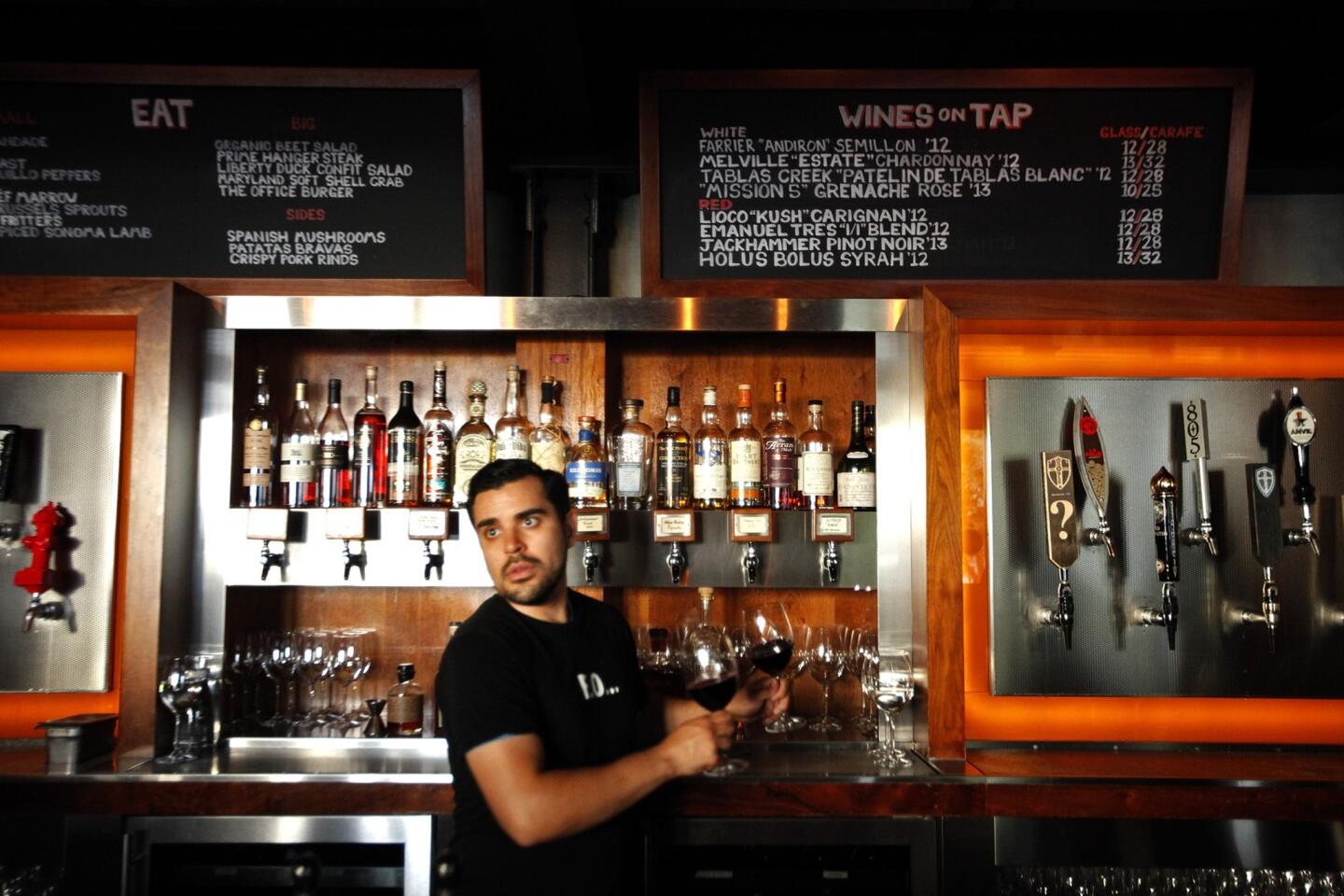 Bartender Erik Solis goes to deliver two glasses of Holus Bolus Syrah, one of the wines on tap at chef Sang Yoon's Father's Office in Culver City. The restaurant was the first in L.A. to offer wines on tap.