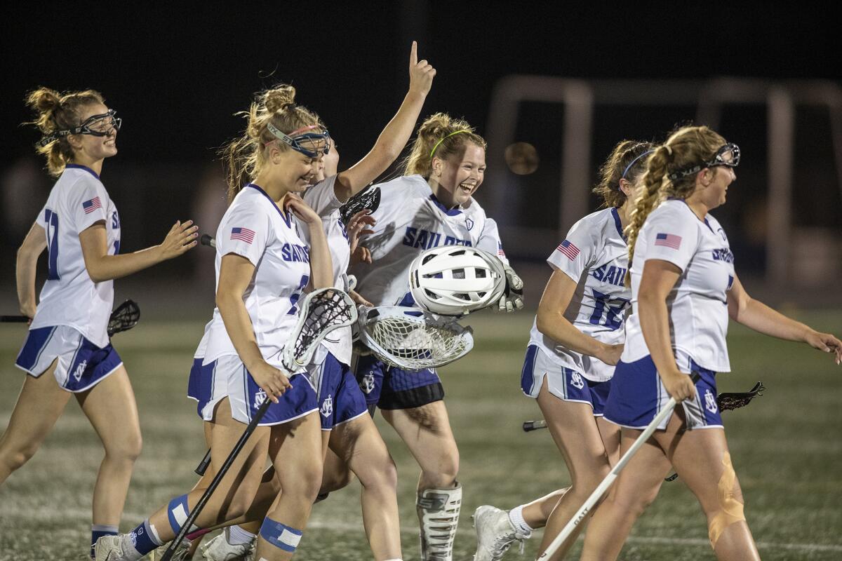The Newport Harbor girls' lacrosse team celebrates after beating Corona del Mar in a CIF Division 2 semifinal on Tuesday.