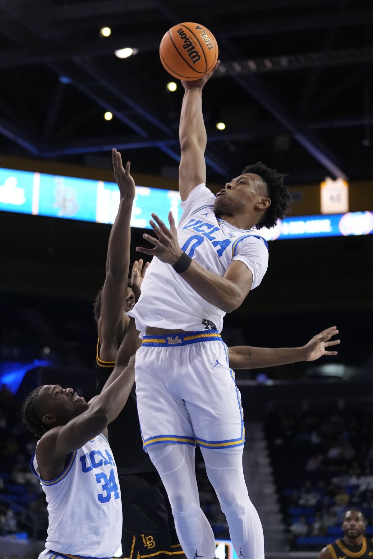 The Bruins' Jaylen Clark (0) grabs a rebound during the first half against Long Beach State on Nov. 11, 2022.