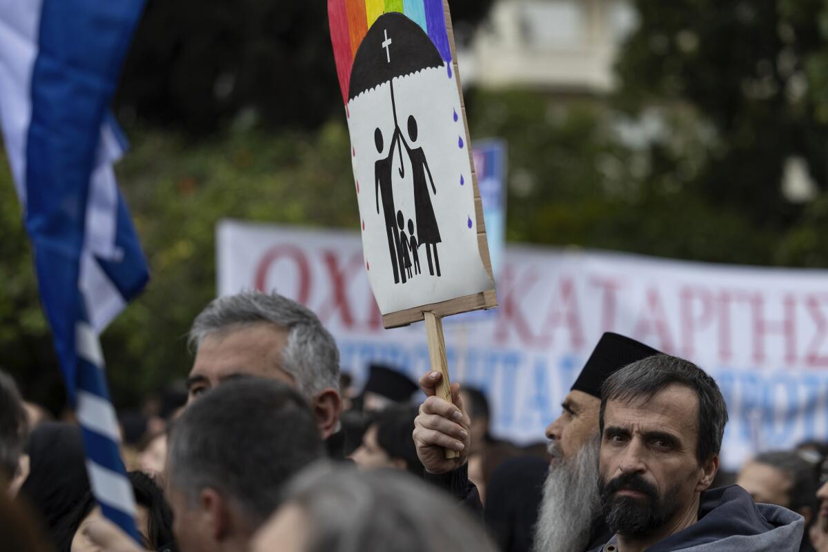 A protester raises a banner during an Athens rally against same-sex marriage.