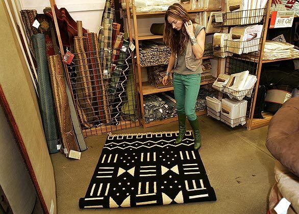 Kelly Wearstler studies a rug that she might buy to use as a beach blanket tabletop for her picnic.