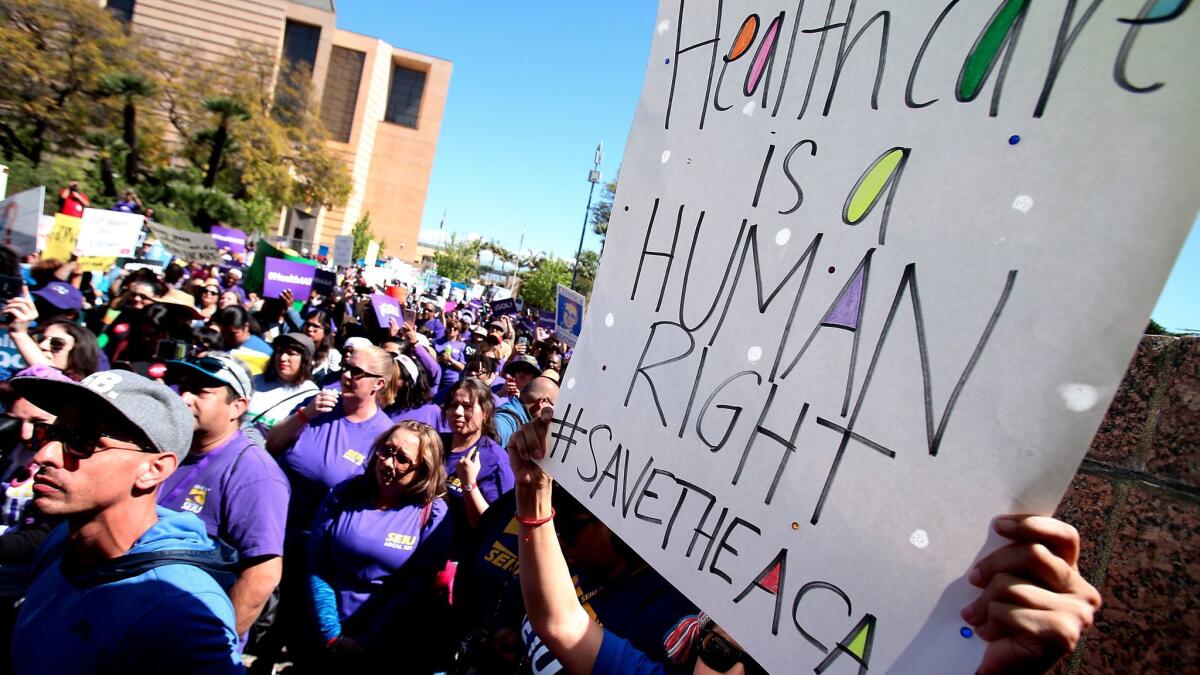 Hundreds of people marched in downtown L.A. in support of saving the Affordable Care Act, also known as Obamacare. (Luis Sinco/Los Angeles Times)