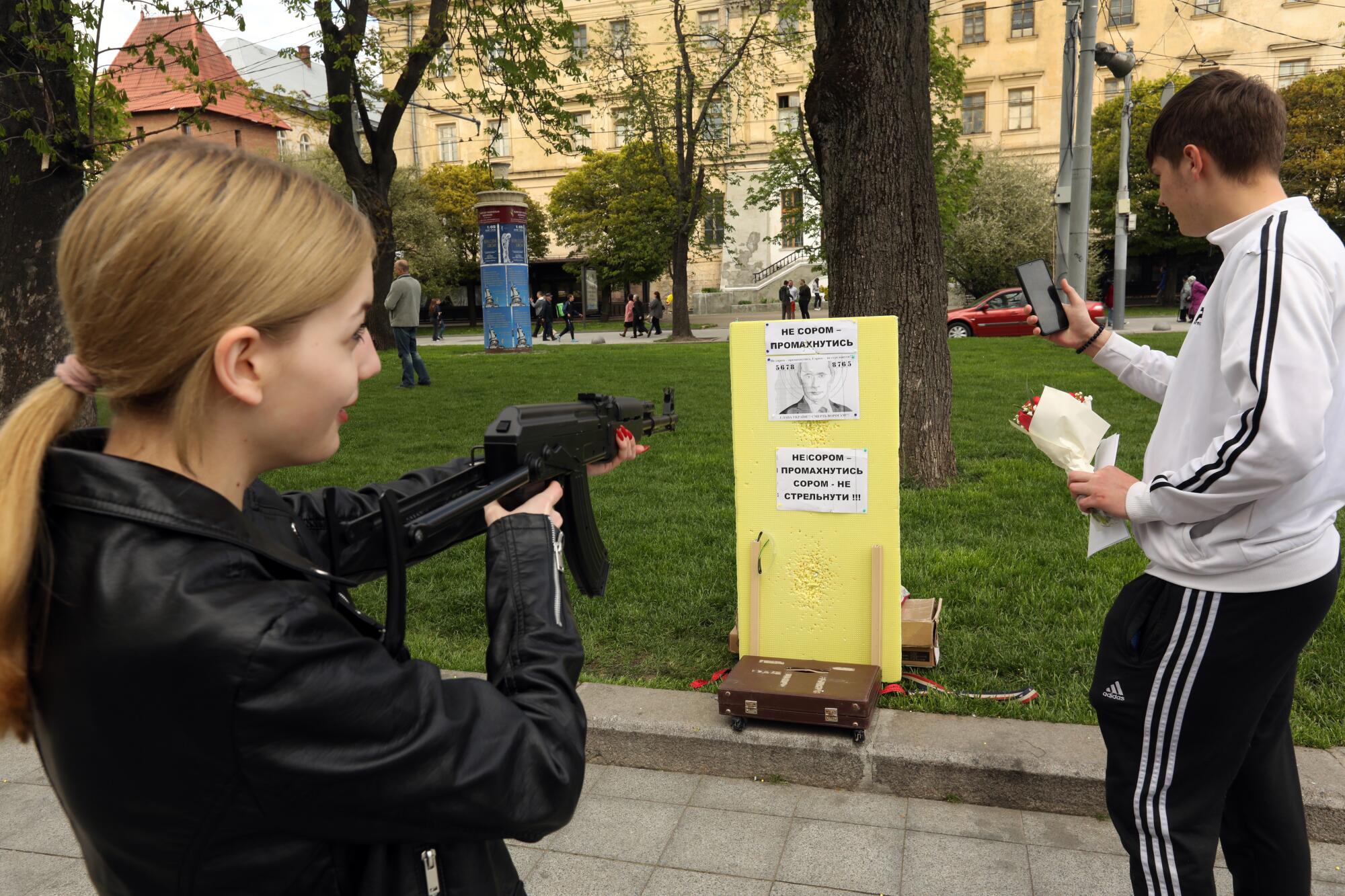A BB gun is aimed at a picture of Putin as a game in downtown Lviv.