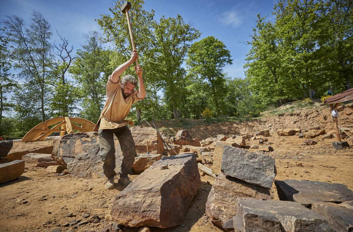 Alexandre Hecker, head quarryman, breaks a stone in the quarry at the Guedelon medieval castle project.
