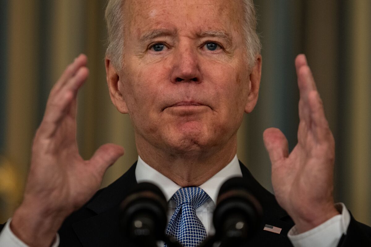 President Biden holds his hands up and looks ahead