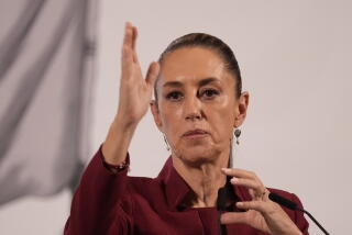 Mexican President Claudia Sheinbaum gestures while speaking at a microphone
