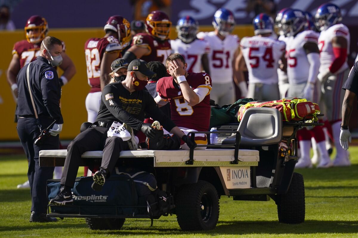 Washington Football Team quarterback Kyle Allen (8) rubs his face as he is carted off the field after injuring his leg in a play against New York Giants in the first half of an NFL football game, Sunday, Nov. 8, 2020, in Landover, Md. (AP Photo/Patrick Semansky)