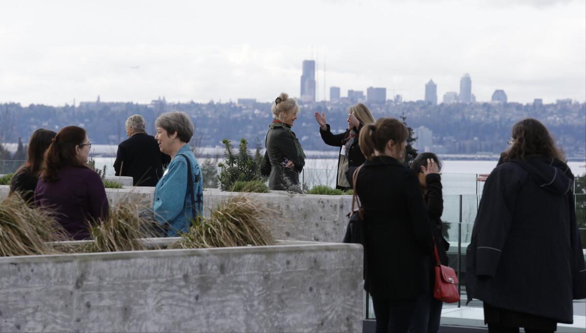 People gather on the roof of a Google building with a view of downtown Seattle and Lake Washington.
