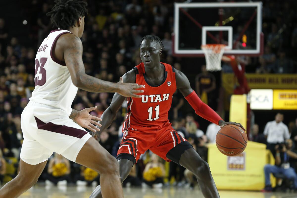 FILE - Utah guard Both Gach (11) advances the ball up-court while Arizona State's Romello White (23) defends during the first half of an NCAA college basketball game in Tempe, Ariz., in this Saturday, Jan. 18, 2020, file photo. Gach switched schools to be closer to his family during the COVID-19 pandemic. Now at Minnesota, the junior guard has been granted immediate eligibility by the NCAA.(AP Photo/Ralph Freso, File)