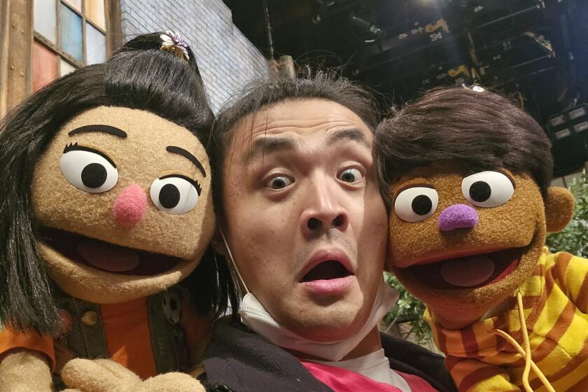 Korean American muppet, Ji-Young with voice actor and puppeteer Yinan Shentu with the new Filipino muppet, TJ.
