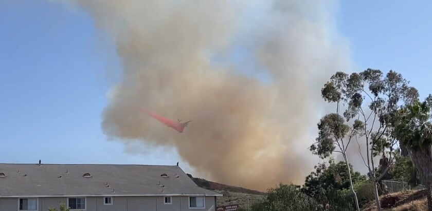 A plane drops retardant on a fire Wednesday afternoon in East County.