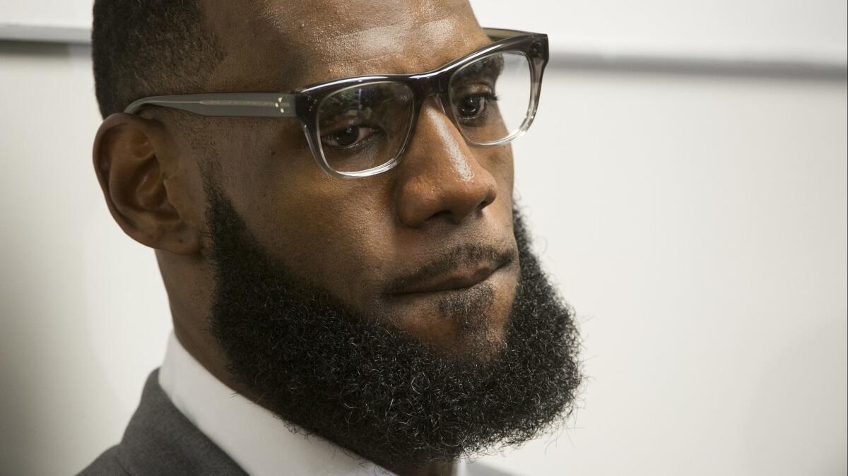 LeBron James listens to a question at a news conference after the opening ceremony for the I Promise School in Akron, Ohio.