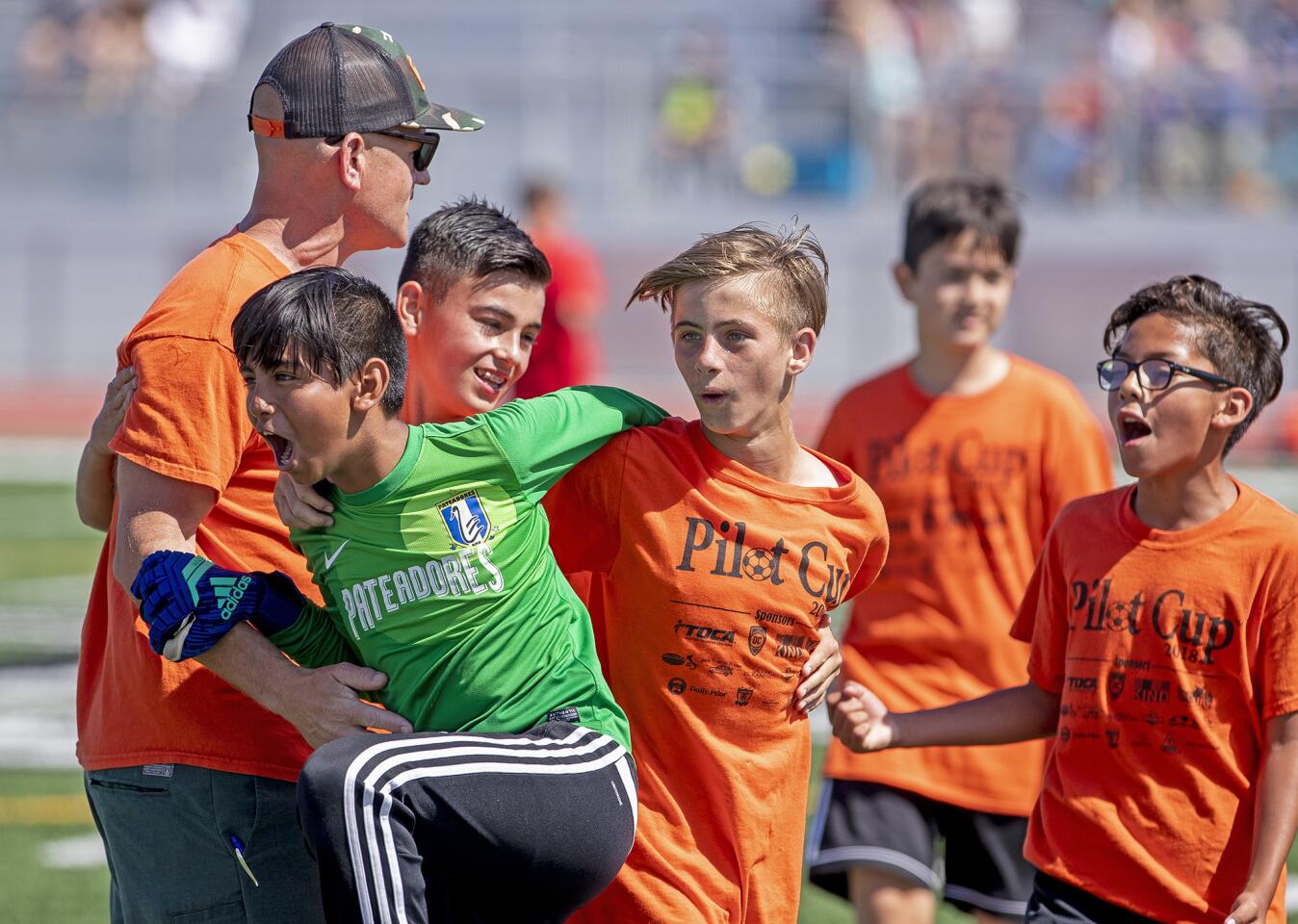 Davis's coach Owen Markert, left, celebrates a 2-0 win over Kaiser with Rocco Villarreal, Luke Sacuy, Kyle DÕAlessandro and Damien Soto Kaiser's following a boysÕ fifth- and sixth-grade Gold Division quarterfinal match at the Daily Pilot Cup on Saturday , June 2.
