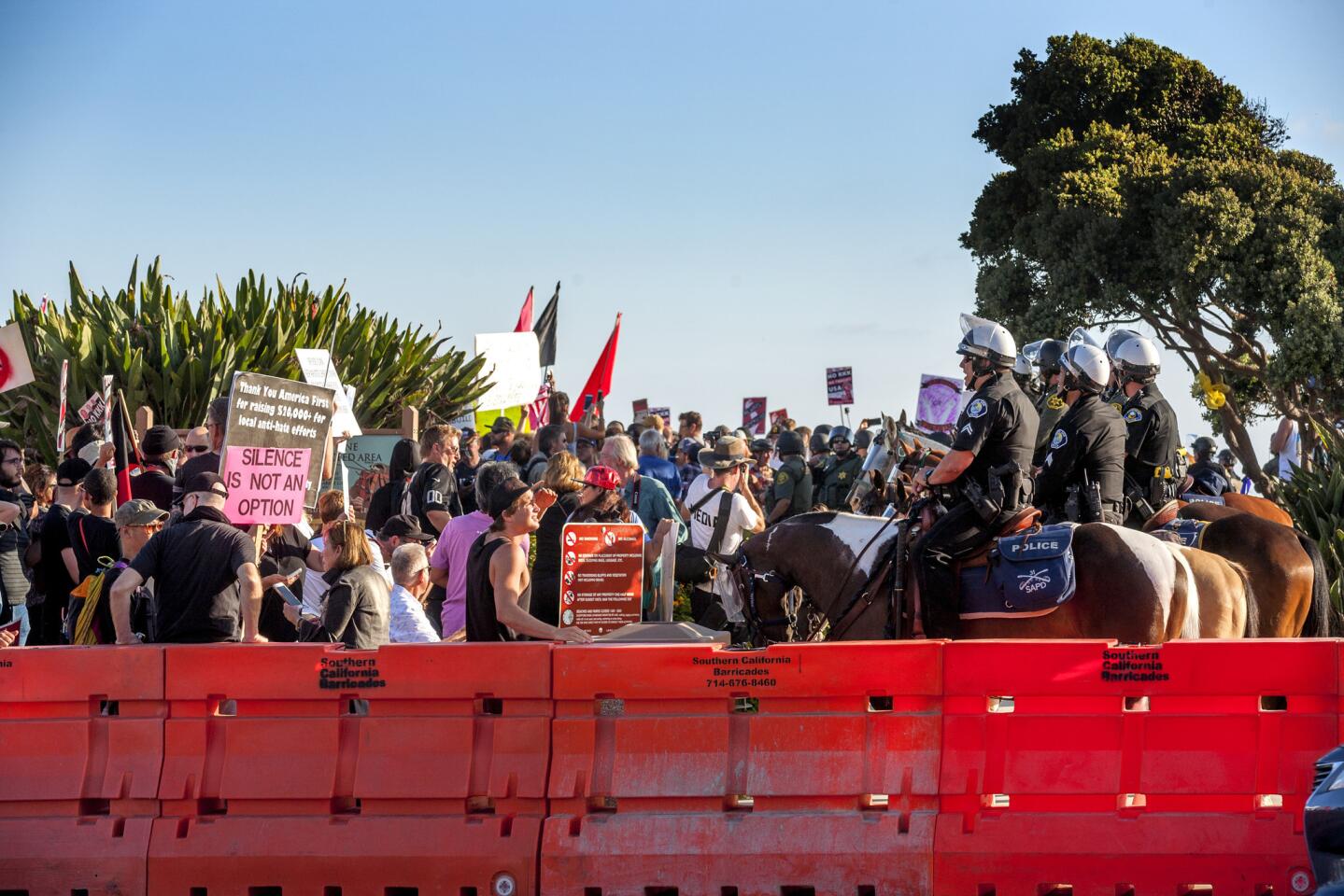 Mounted police keep anti-illegal immigration demonstrators and counter-protesters separated during Sunday's rally in Laguna Beach.