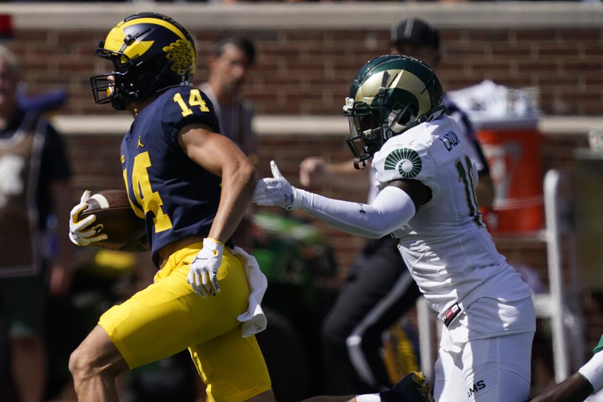 Michigan wide receiver Roman Wilson pulls away from Colorado State defensive back Greg Laday.