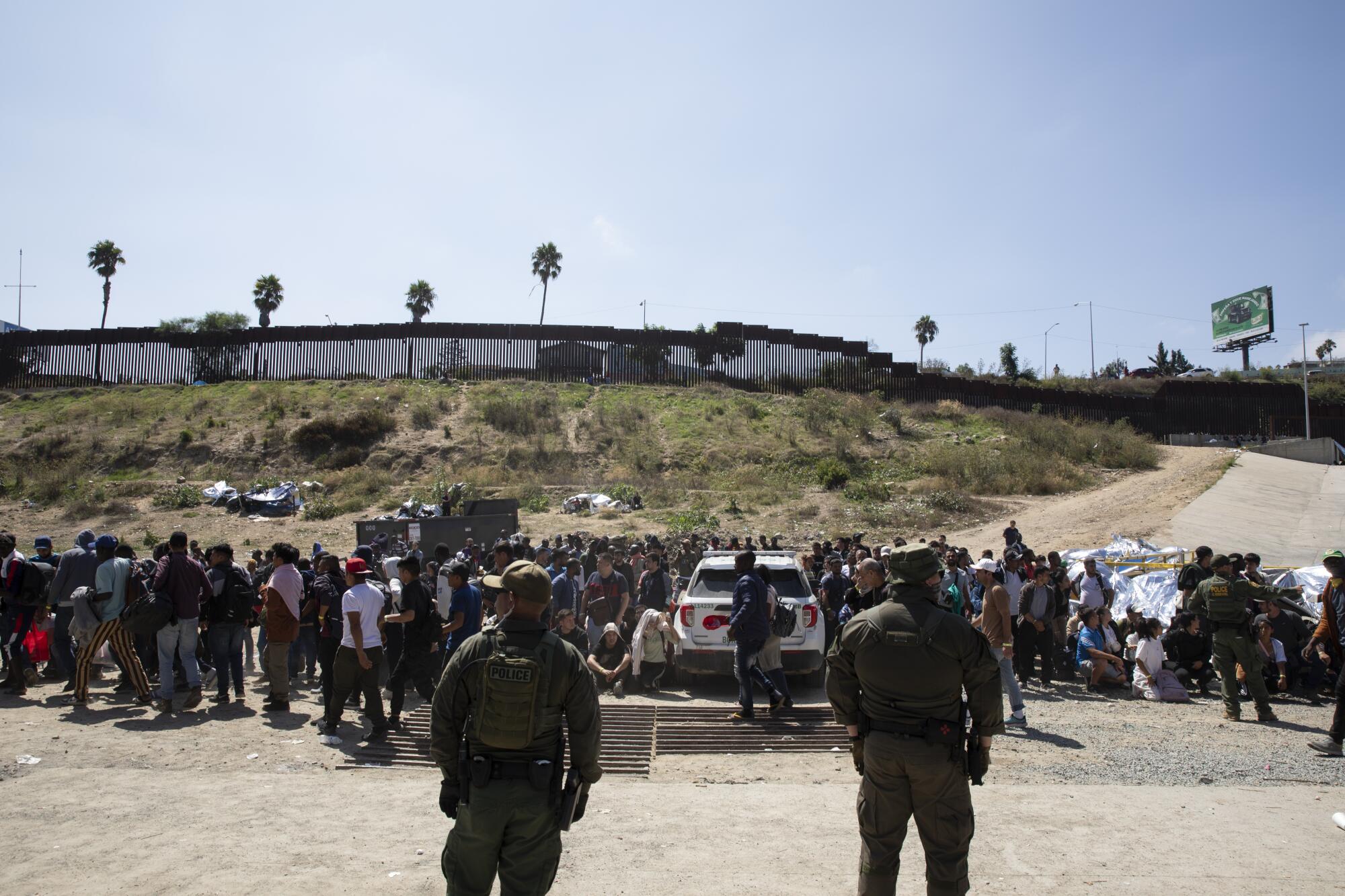 Border agents prepare to begin processing more than 400 asylum seeking migrants who are between the U.S.-Mexico border walls
