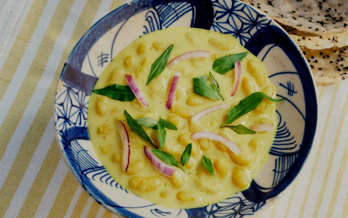 A bowl of white beans with coconut lemongrass broth 
