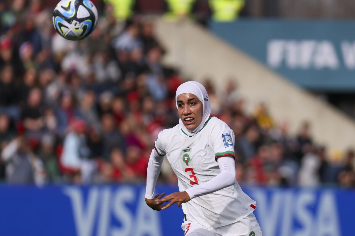 モロッコのヌハイラ・ベンジナがワールドカップの試合でヒジャブをかけてボールを追いかけている。