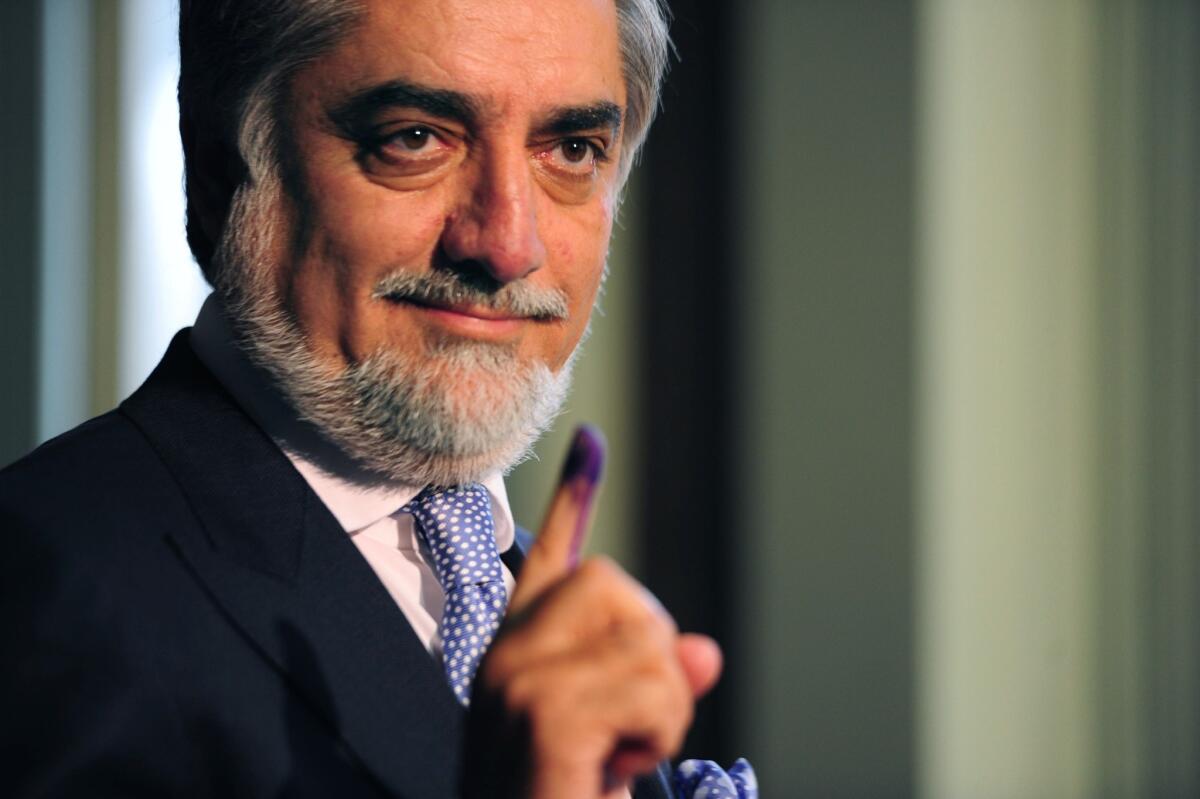 Afghan presidential candidate Abdullah Abdullah shows his inked finger as he casts his vote at a local polling station in Kabul.