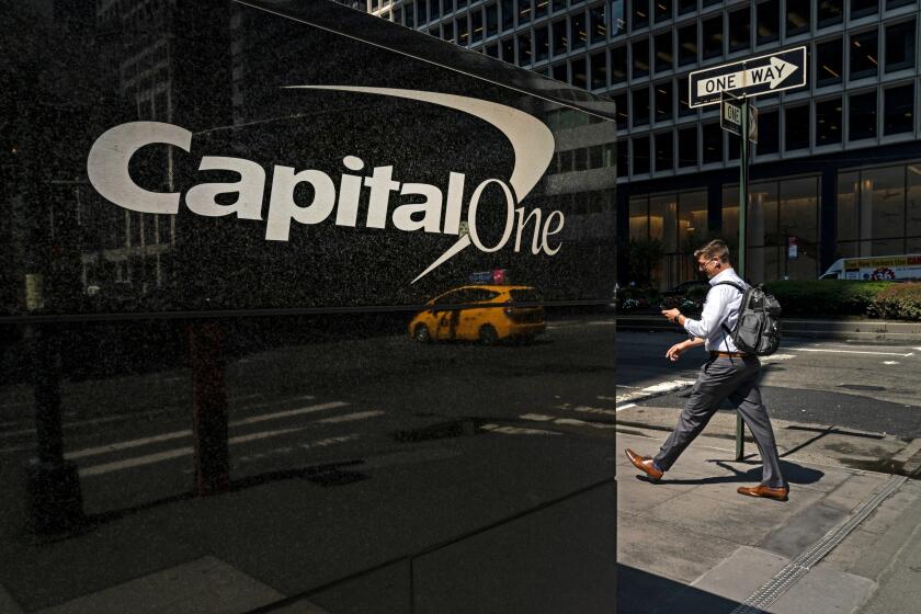 NEW YORK, NY - JULY 30: A man checks his phone as he walks past the Capital One offices in Midtown Manhattan on July 30, 2019 in New York City. In one of the largest-ever thefts of bank data, a software engineer in Seattle was arrested for hacking into a Capitol One server and obtaining the personal data of over 100 million people. The data includes social security numbers, bank account numbers, names, addresses, credit scores, credit limits, balances, and other information. (Photo by Drew Angerer/Getty Images)