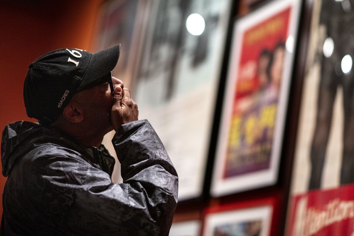 Spike Lee holds his hand over his mouth as he views memorabilia at the new Academy Museum of Motion Pictures.