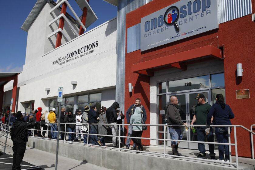 FILE - In this March 17, 2020 file photo, people wait in line for help with unemployment benefits at the One-Stop Career Center in Las Vegas. A record-high number of people applied for unemployment benefits last week as layoffs engulfed the United States in the face of a near-total economic shutdown caused by the coronavirus. The surge in weekly applications for benefits far exceeded the previous record set in 1982. (AP Photo/John Locher, File)