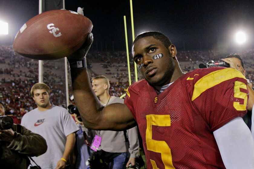 USC running back Reggie Bush walks off the field holding the game ball after the Trojans defeated Fresno State in 2005.